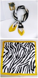 Detail of silk-like square scarf with zebra animal print and yellow border accent