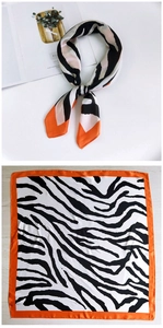 Detail of silk square scarf featuring zebra print pattern with bright orange border