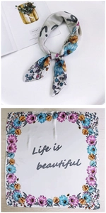 Detailed view of square silk scarf with floral borders and Life is beautiful quote