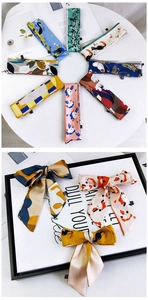 Détail d'un foulard en soie aux imprimés tropicaux colorés et aux motifs géométriques