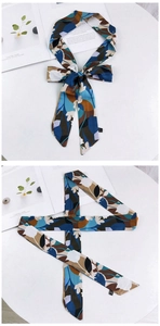 Détail d'un foulard en soie vintage noué en nœud avec motifs floraux abstraits bleu marine