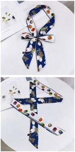 Détail d'un foulard en soie bleu et blanc à motif papillon noué en nœud décoratif
