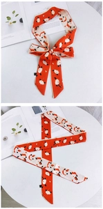 Gros plan d'un foulard Twilly orange et crème avec des motifs de pandas mignons