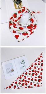 Détail d'un foulard triangle blanc avec imprimés fraises rouges et feuilles vertes