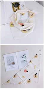 Détail du foulard triangulaire en soie avec imprimés de pêches et texture légère