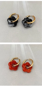 Dettaglio di orecchini a cerchio placcati oro 18K con fiori in resina neri e rossi