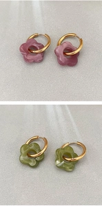 Dettaglio macro di orecchini a fiori placcati oro 18K in resina marmorizzata viola e verde