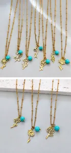 Detailed view of assorted gold floral pendant necklaces with turquoise beads and beaded chains