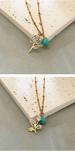 Macro detail of gold flower pendant with turquoise bead on delicate stainless steel chain