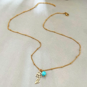 Gold birthstone necklace with December flower pendant and turquoise bead on link chain