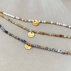 Trois bracelets perlés plaqués or 18 carats avec pierres naturelles et pendentifs martelés