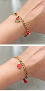 Close-up of gold chain bracelet with red watermelon and apple enamel fruit charms