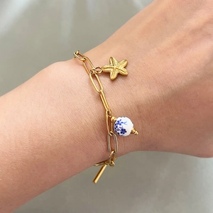 Bracelet étoile de mer doré avec perle céramique bleue sur chaîne minimaliste au poignet