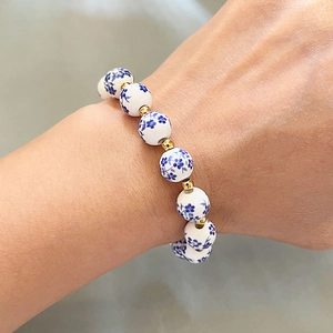 Retro blue and white porcelain beaded bracelet with 18k gold accents on woman's wrist