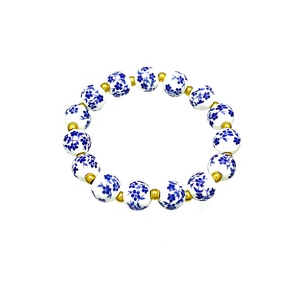 Blue and white porcelain bead bracelet with 18k gold-plated accents on a white background