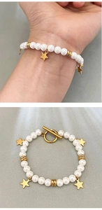 Detail of baroque pearl bracelet with star charms and toggle clasp on a hand