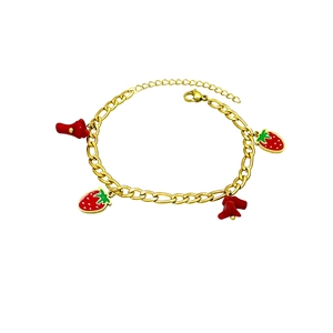 Gold Figaro chain bracelet featuring red strawberry and cherry charms with lobster clasp