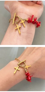 Detail of OT toggle clasp and golden cross charms on a red coral beaded bracelet
