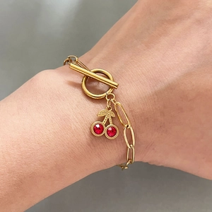 Bracelet en acier doré avec pendentif cerise en strass rouges et fermoir à bascule