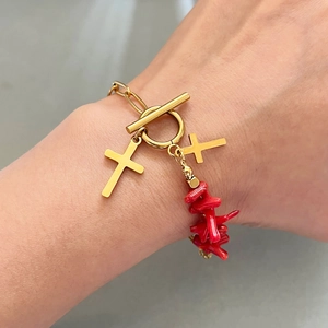 Golden OT buckle bracelet with twin crosses and irregular red coral beads on wrist