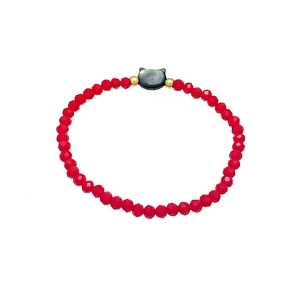 Red beaded bracelet with a black cat charm and gold accents on a clean white background
