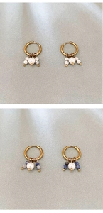 Dettaglio di orecchini vintage francesi con perle in pietra naturale e finitura oro