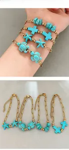 Dettaglio di un set di bracciali a graffetta dorati bohémien con ciondoli turchesi