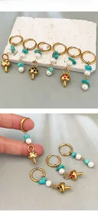 Detail of mushroom drop earrings with turquoise stones, pearls, and gold hoops