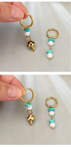 Detail of mushroom earrings with turquoise stone and pearl on gold hoops