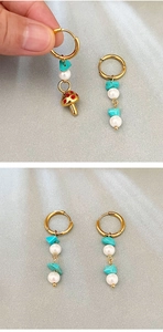 Detail of gold mushroom hoop earrings with turquoise stones and white pearls