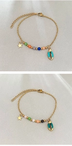 Détail du bracelet en chaîne dorée avec breloque étoile de mer, perles et pendentif coquillage