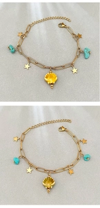 Detail of gold star charms, turquoise stones and shell pendant on bohemian chain