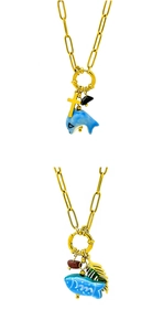 Detail of 18K gold plated marine necklaces with dolphin and fish ceramic charms