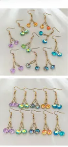 Close-up of colorful cherry-shaped glass drop earrings with faceted crystal beads
