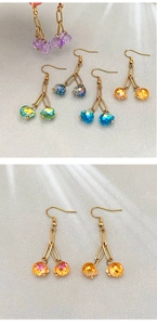 Detail showing colorful crystal cherry drop earrings with faceted glass beads and gold hooks