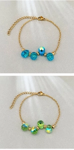Macro detail of 18k gold chain with blue and green faceted crystal teardrop beads