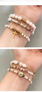 Détail d'un ensemble de bracelets en perles d'eau douce avec breloques étoile dorée