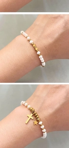 Détail de bracelets en perles d'eau douce avec breloques croix et étoile en or 18K