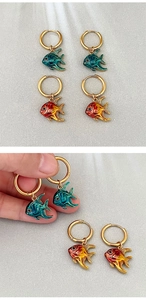 Détail de boucles d'oreilles poisson rouge avec émail dégradé bleu et orange élégant