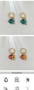 Détail de boucles d'oreilles poisson en émail coloré avec dégradés et anneaux dorés