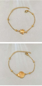 Detail of gold seashell and sea turtle pendants on a stylish stainless steel bracelet