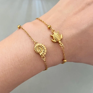 Golden sea turtle and nautilus shell charm bracelets set for women on model wrist