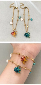 Close-up of 18K gold-plated fish pendant bracelets with freshwater pearls and blue stones