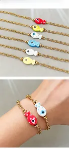 Detail of 18k gold plated stainless steel bracelets with colorful ceramic fish charms