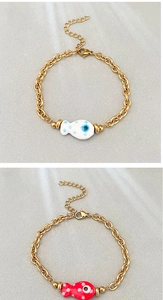 Detail view of 18k gold plated stainless steel bracelets with blue and red fish charms