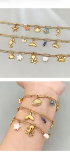 Detail of gold ocean charm bracelets with starfish, dolphin and sea horse pendants