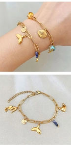 Detail of gold ocean charm bracelet with seahorse and starfish on clip chain
