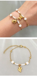 Macro detail of gold beaded bracelet featuring heart, bow, and cactus charm pendants