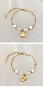 Detail of gold beaded bracelets featuring heart and bow charms with white pearls