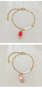 Détail de bracelets à breloques tulipes avec perles blanches et chaînes dorées